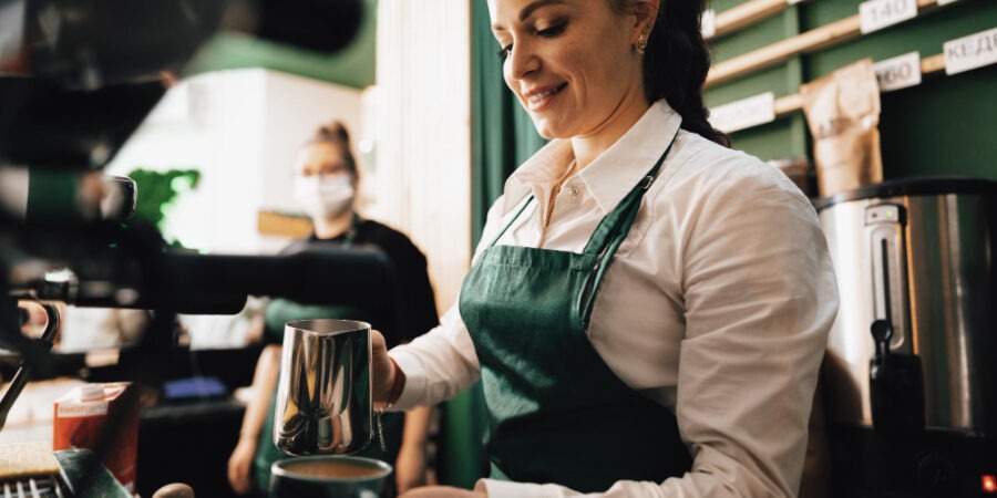 Caucasian female barista at work making coffee