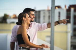 Happy couple standing in the balcony and having some romantic time together