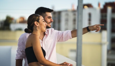 Happy couple standing in the balcony and having some romantic time together