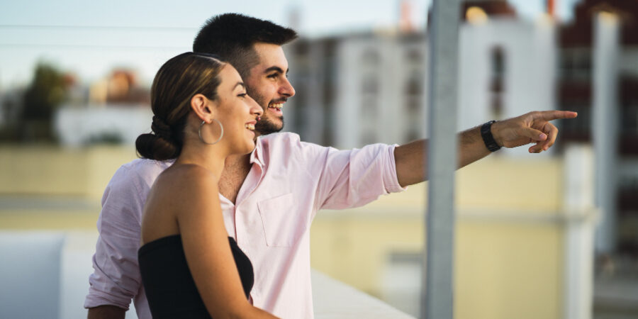 Happy couple standing in the balcony and having some romantic time together